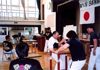比田井 高廣さん(右腕で腕相撲を取っている白いシャツ側)